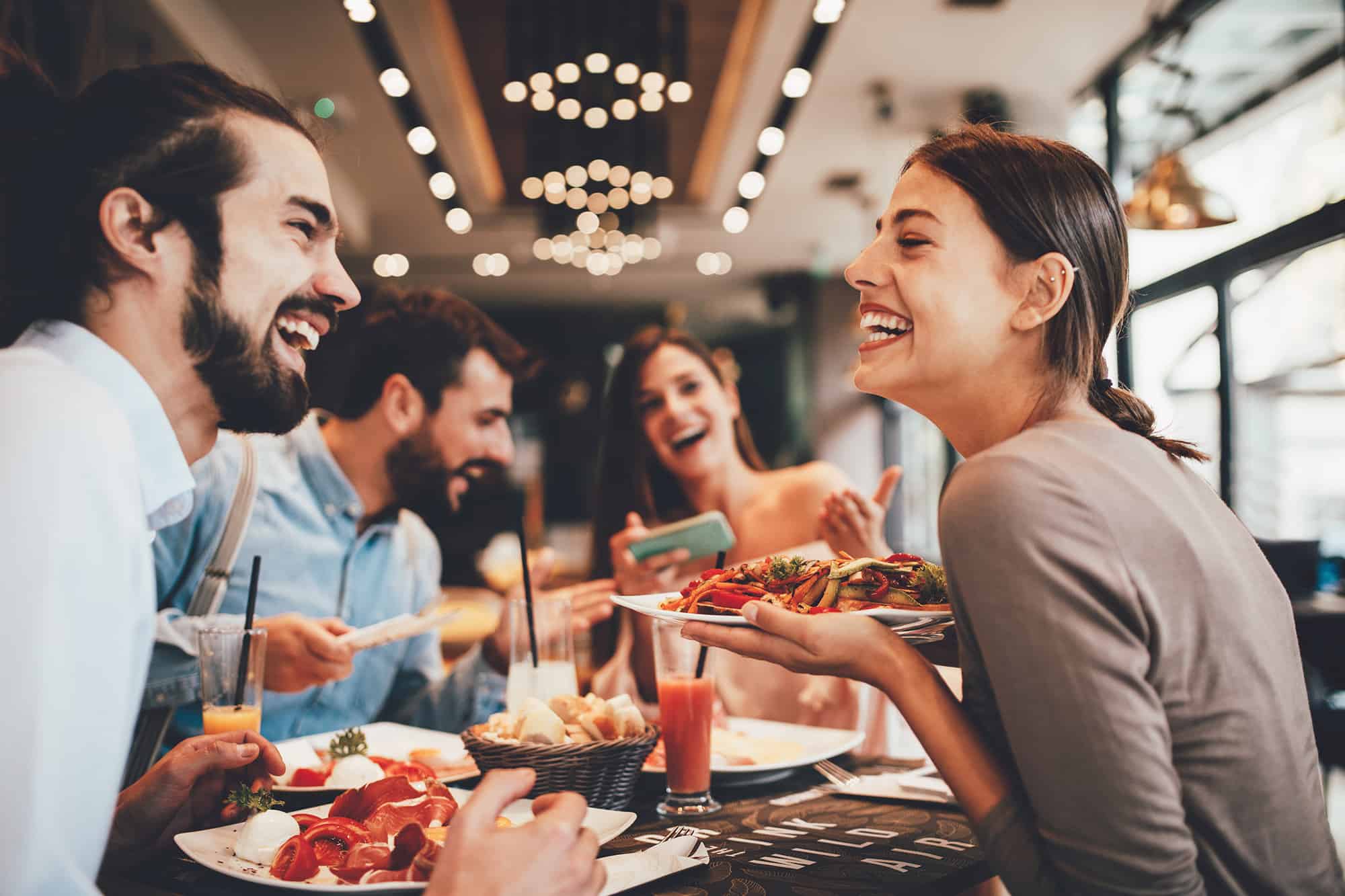 Group of Happy friends having breakfast in the restaurant